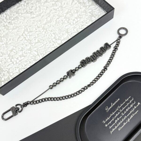Chain belt made of pearls, beads,metallic letters that spell out VU!TT0N.JW01