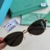 Sunglasses in Pale Gold-colored Metal with Black cat-eye shaped lenses.