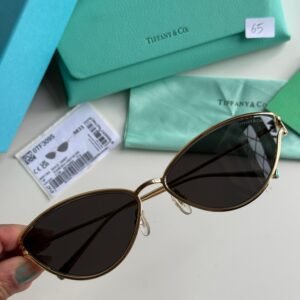 Sunglasses in Pale Gold-colored Metal with Black cat-eye shaped lenses.