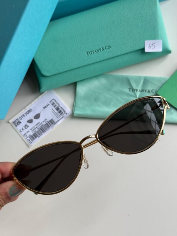 Sunglasses in Pale Gold-colored Metal with Black cat-eye shaped lenses.