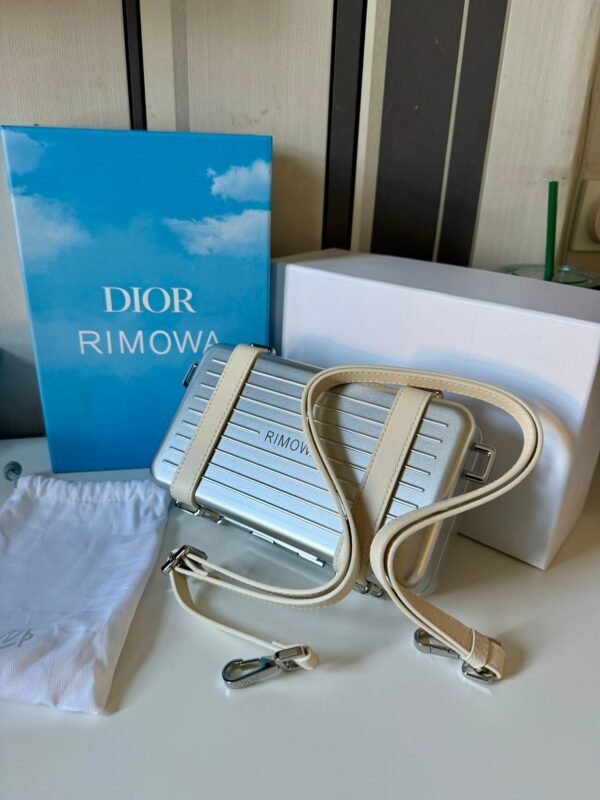 Spring 2020 Personal Clutch On Strap lightweight aluminum with logo-embossed leather straps, refined interior layout with compartments, card slots, and a zippered pocket.