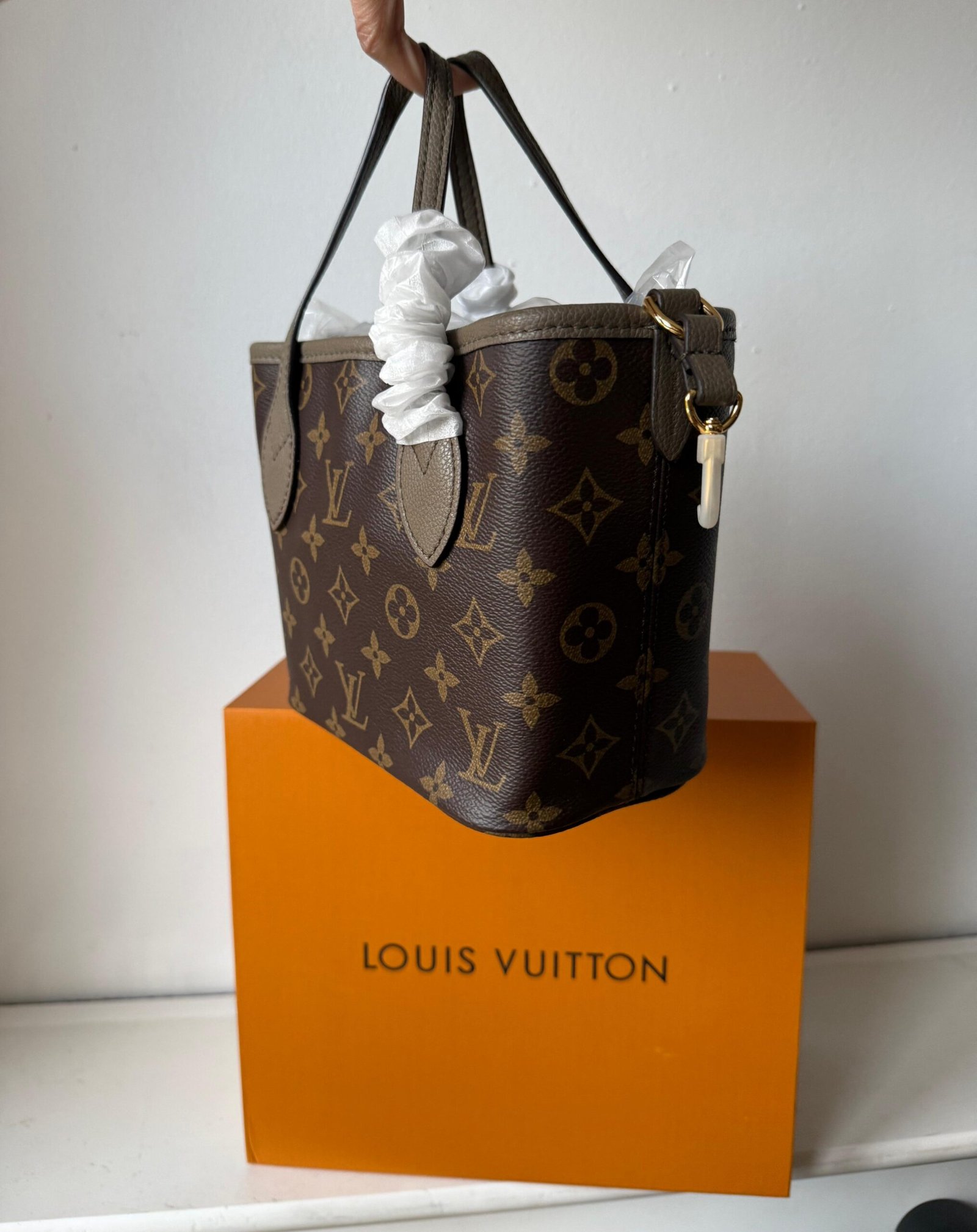 Neverfull Bandoulière Inside Out BB Grained cowhide leather and Monogram canvas.