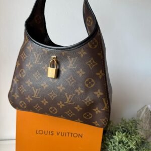 The Drop PM signature with black leather trims and padlock in a gold-toned finish.