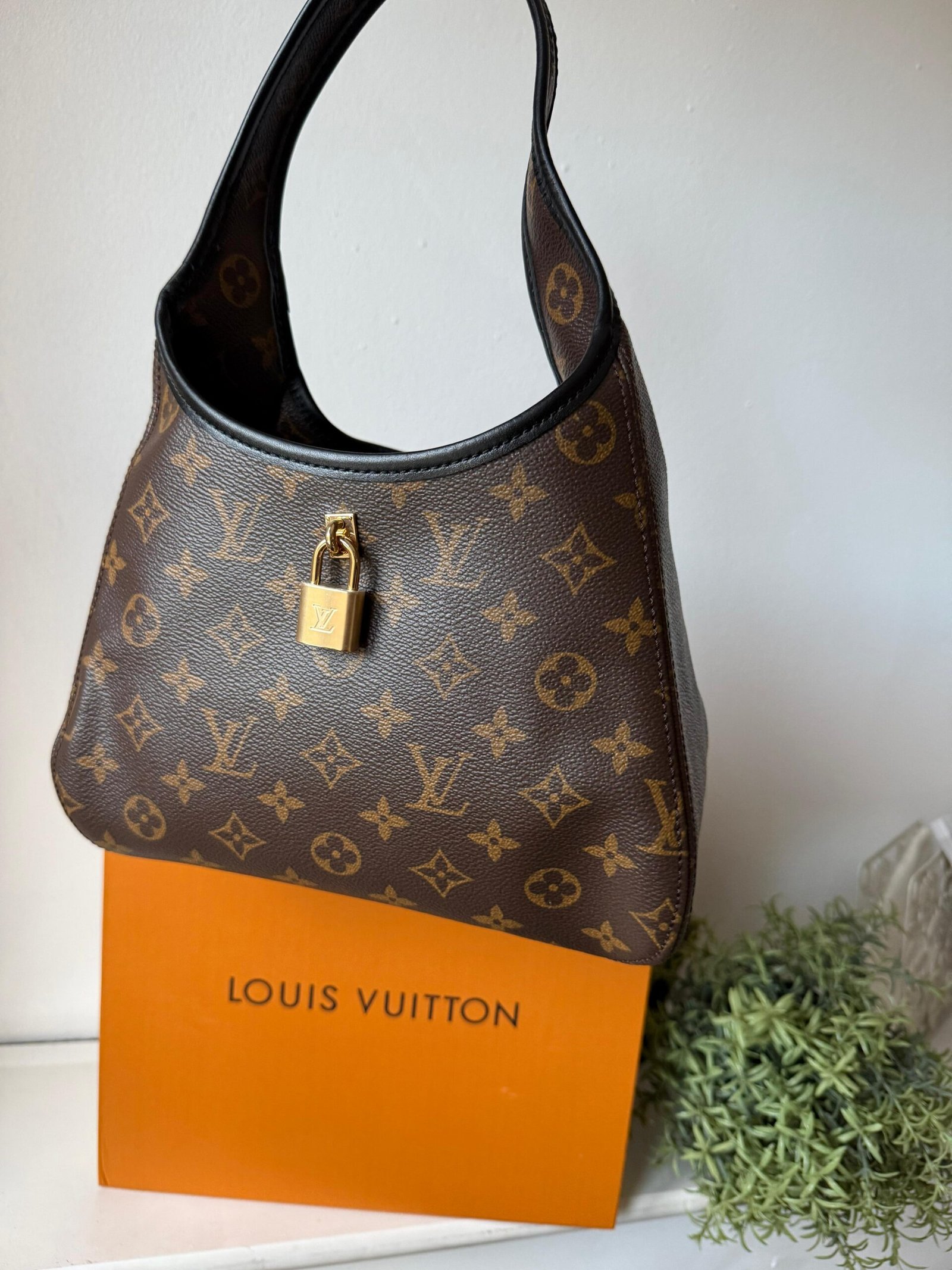 The Drop PM signature with black leather trims and padlock in a gold-toned finish.