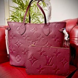 Genuine Leather Neverfull MM Burgundy tote bag with a matching pouch, both featuring embossed monogram pattern.