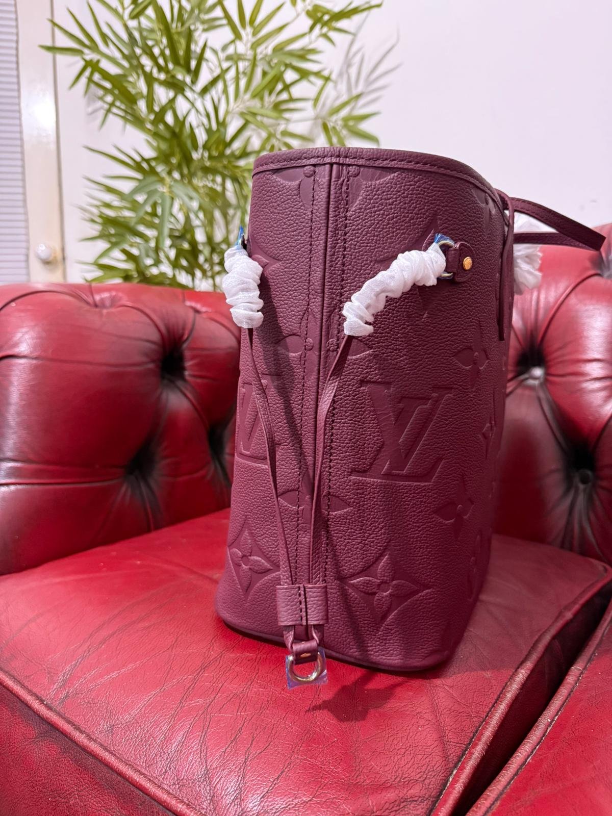 Genuine Leather Neverfull MM Burgundy tote bag with a matching pouch, both featuring embossed monogram pattern. - Image 4