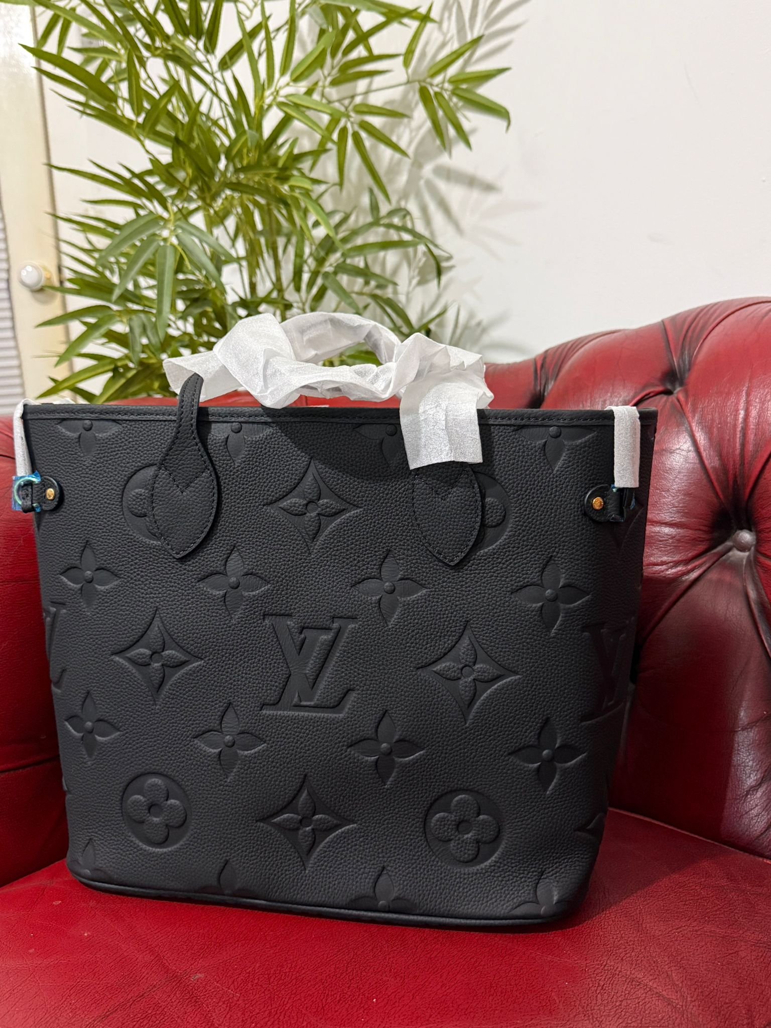 Genuine Leather Neverfull MM Black tote bag with a matching pouch, both featuring embossed monogram pattern. - Image 4
