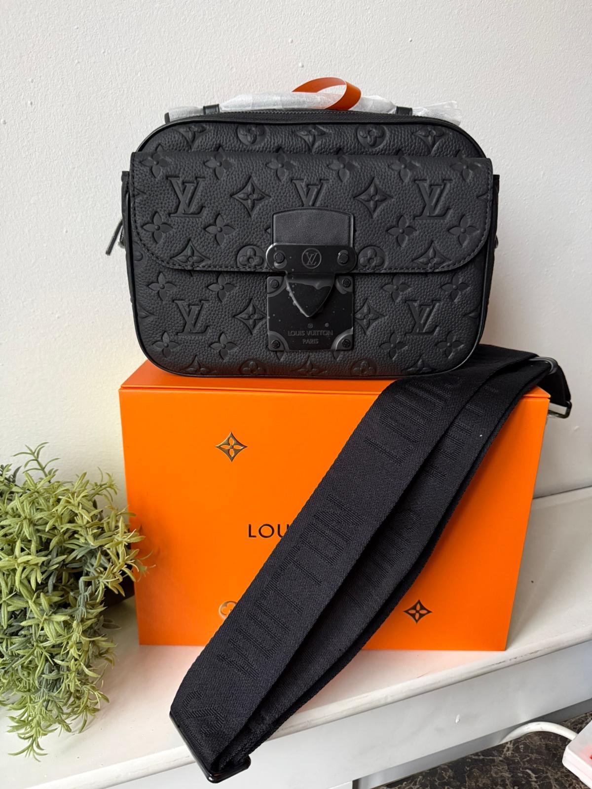 S Lock Messenger crafted in supple black Taurillon leather and embossed with Monogram pattern.