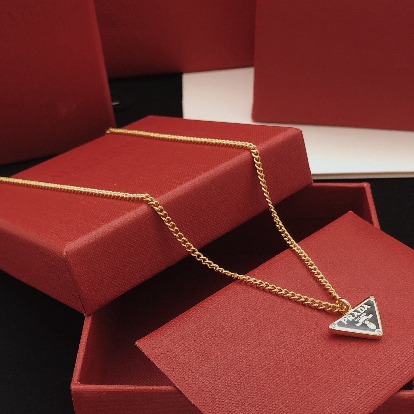 Gold-tone chain necklace featuring a black enamel triangle logo pendant consistent ZP brass.. - Image 4