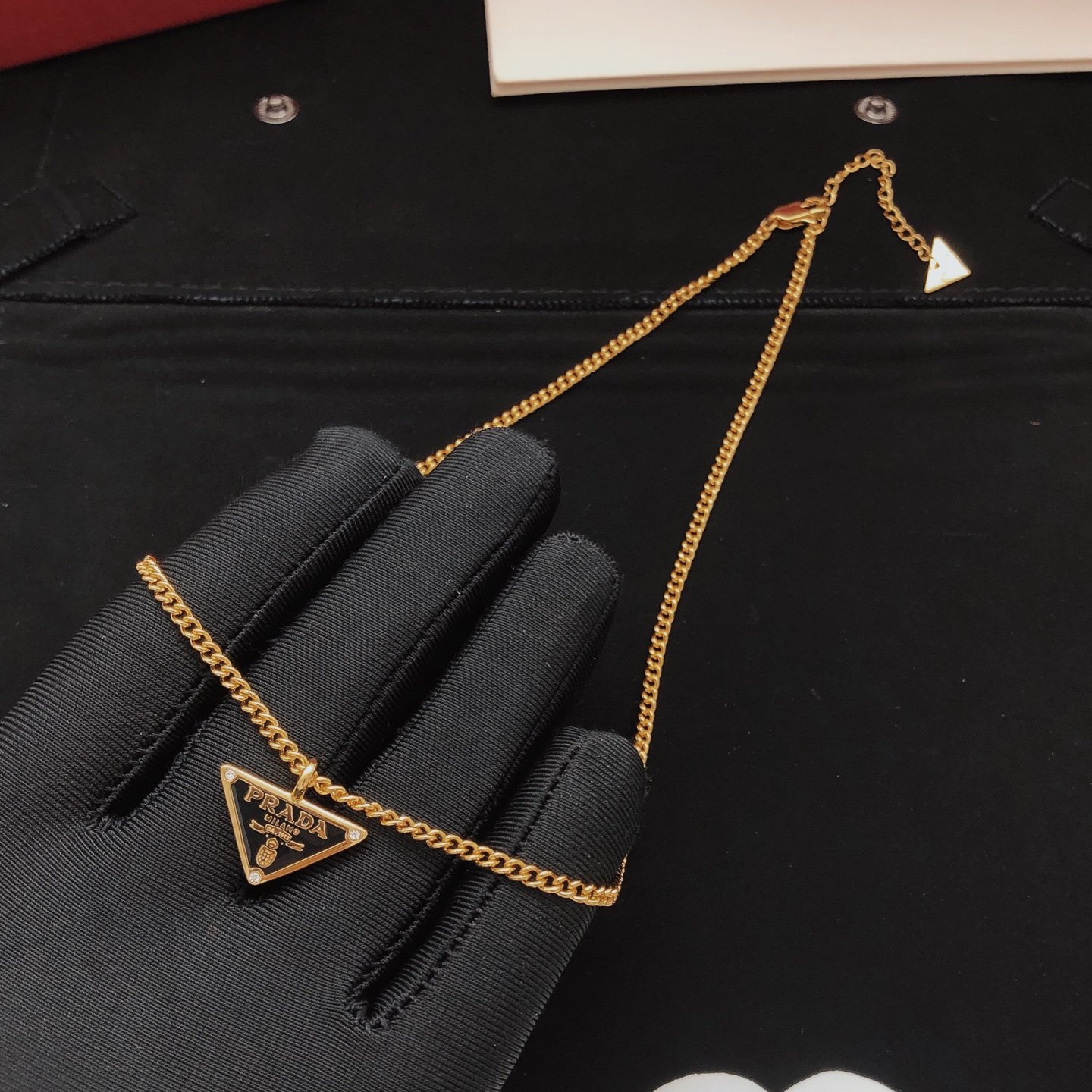 Gold-tone chain necklace featuring a black enamel triangle logo pendant consistent ZP brass.. - Image 3