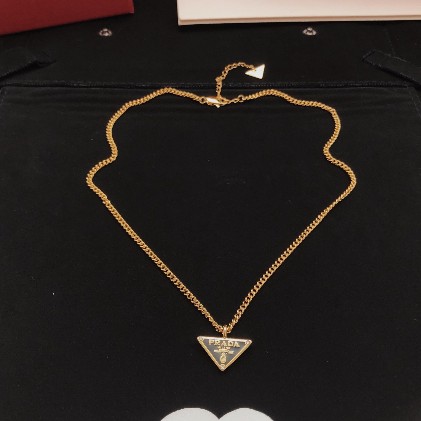 Gold-tone chain necklace featuring a black enamel triangle logo pendant consistent ZP brass.. - Image 2
