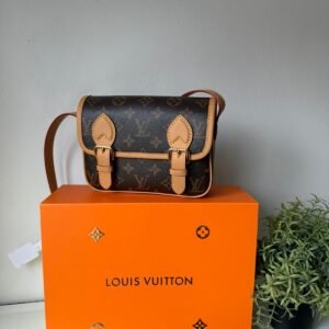 The Satchel Wearable Wallet in Monogram canvas with gold-tone hardware and adjustable shoulder strap.