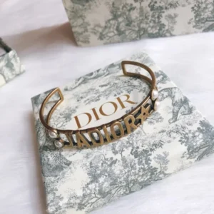Gold bracelet/Bangle with J@D!0R cut out and pearls.