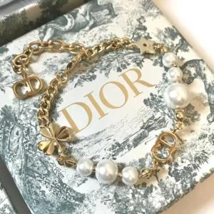 Linked chain gold Bracelet with CD cutout, clover leaf motif and white pearls.