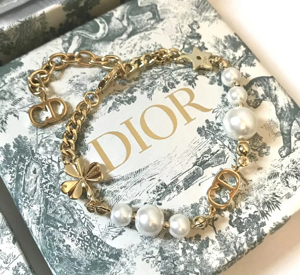 Linked chain gold Bracelet with CD cutout, clover leaf motif and white pearls.