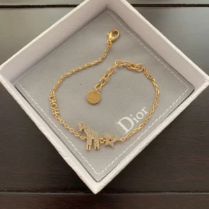 Linked chain gold bracelet with diamond inlaid star and giraffe motif.