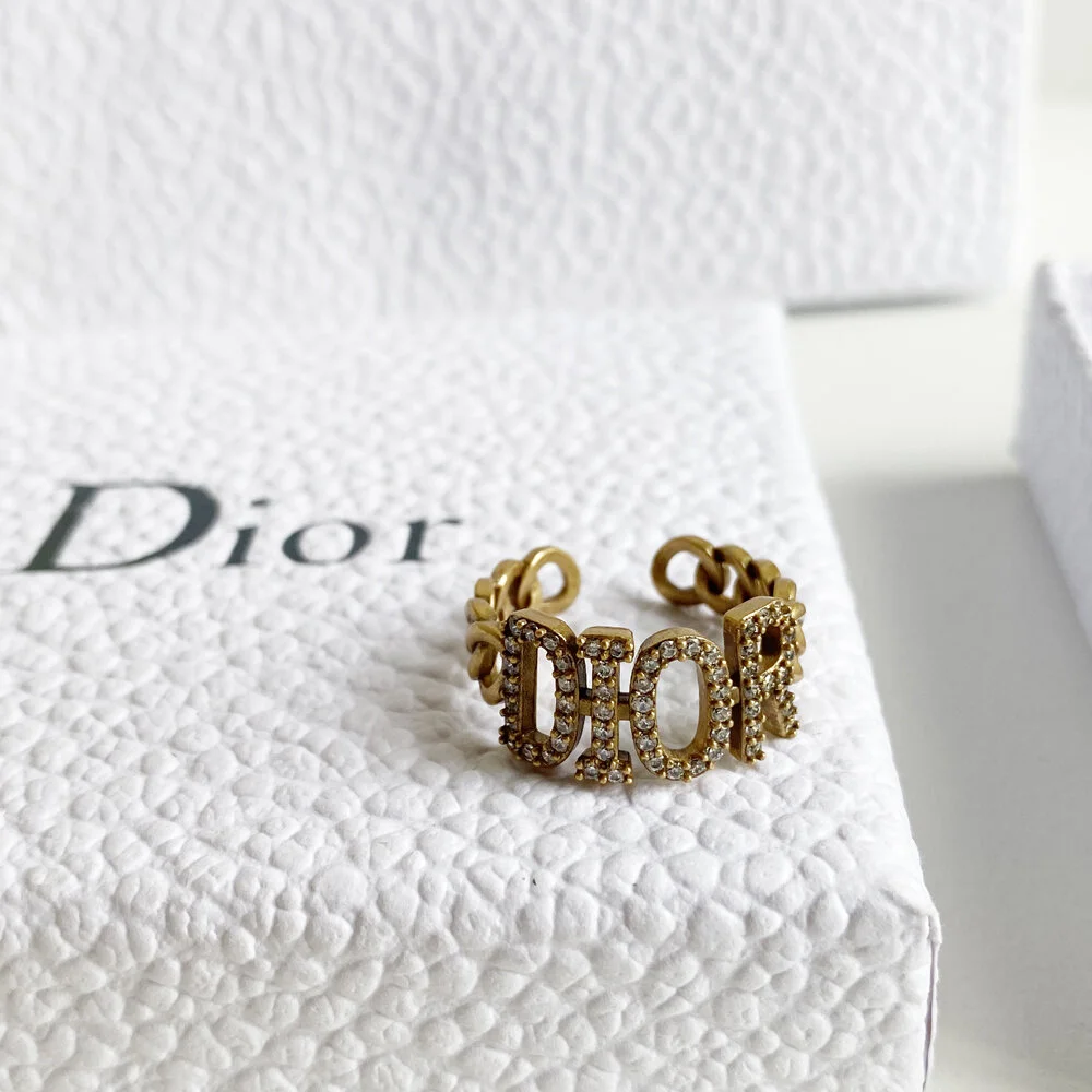 Gold ring with gems and brand name engraved on it.