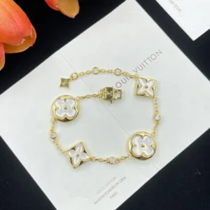 Bracelet is crafted from 18-karat yellow gold with diamonds and white mother-of-pearl blossoms.
