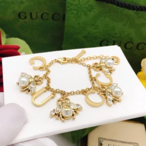 Alternative view of Golden linked chain bracelet with metal cutout and bee charms made of pearls and diamonds.