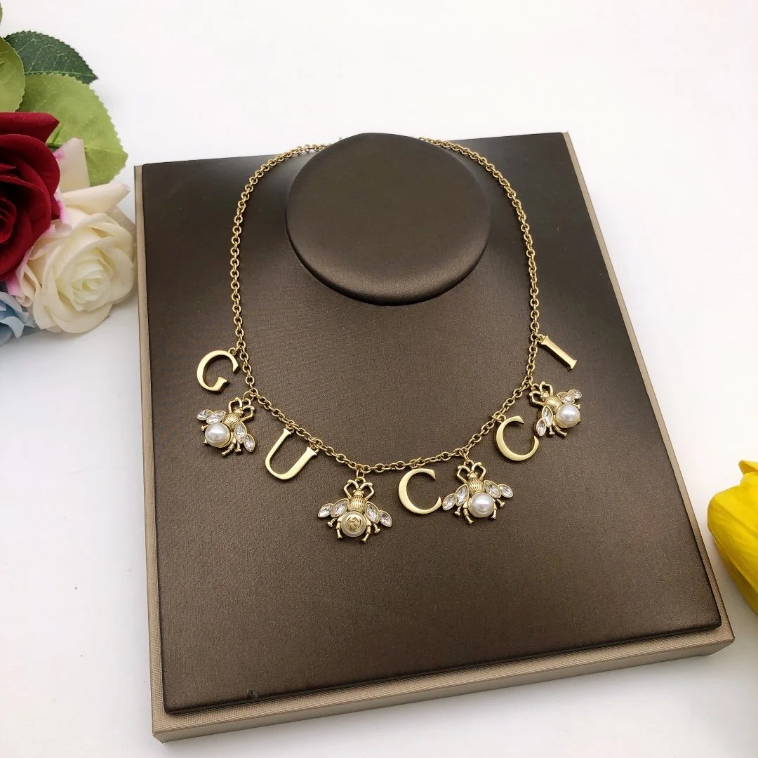 Golden linked chain necklace with metal cutout and bee charms made of pearls and diamonds. - Image 5
