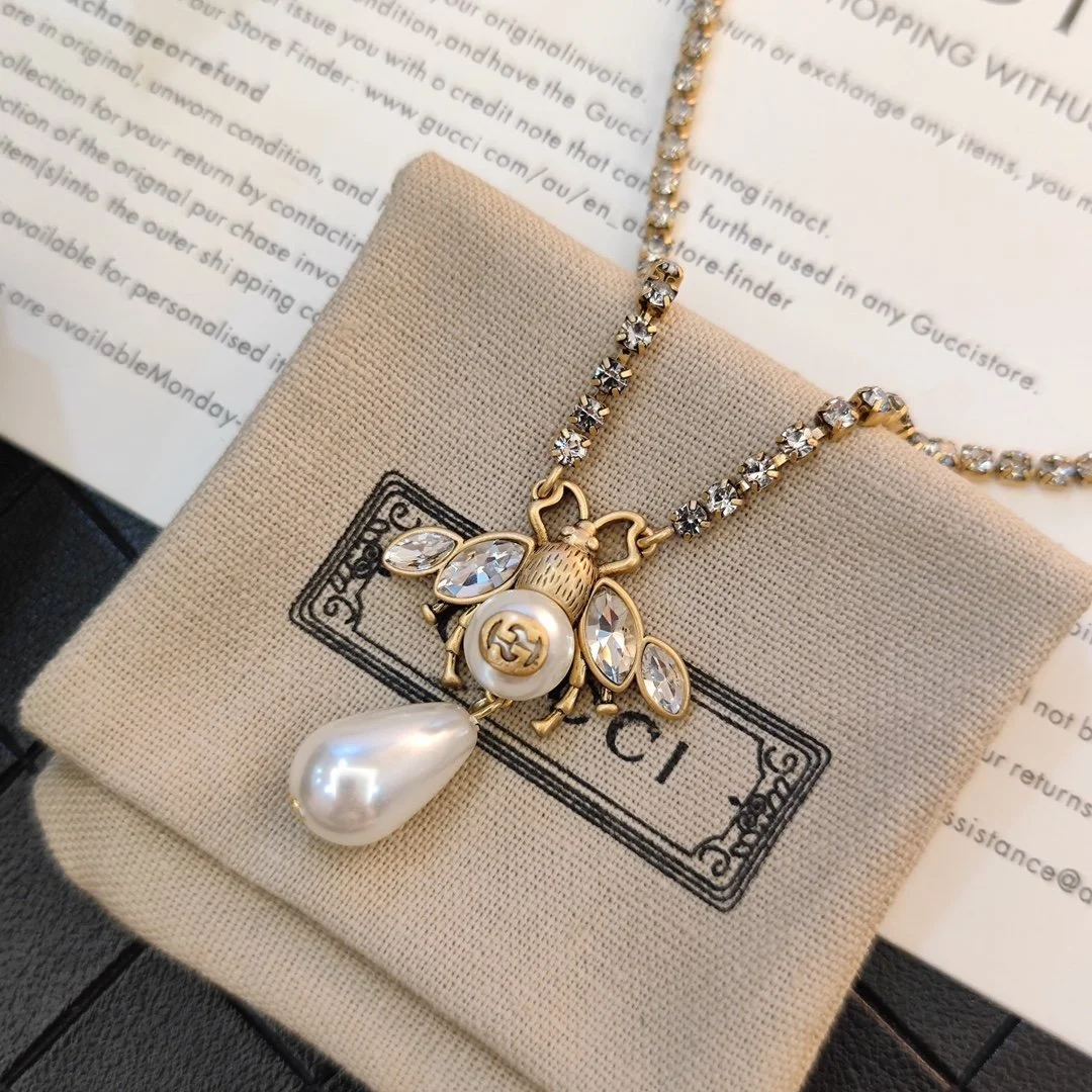 Diamond inlaid golden necklace with bee charm made pearls and diamonds.